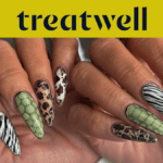 Two hands showing off long almond-shaped nails in assorted animal prints, including zebra stripes, leopard spots, green snakeskin and tortoiseshell.